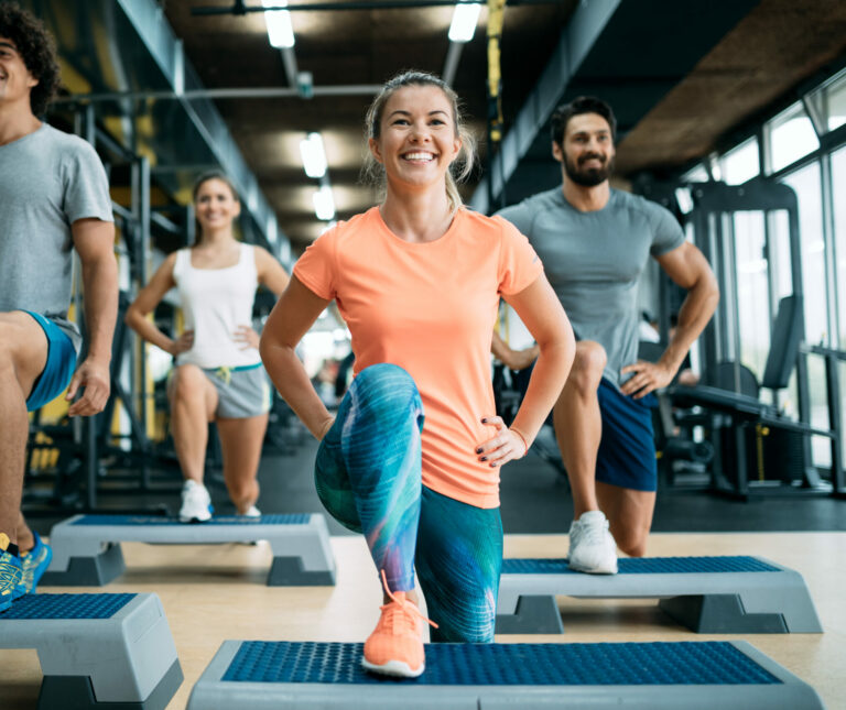 A group of people performing a stretch in a gym class